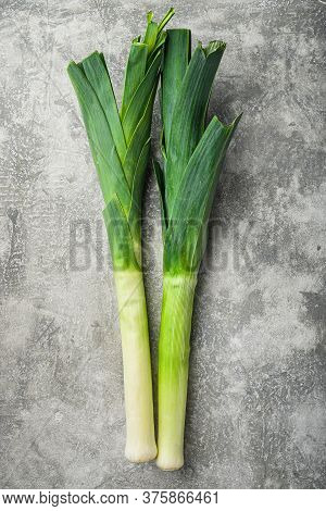 Organic Green Leek Onion On Grey Textured Background, Top View With Space For Text.