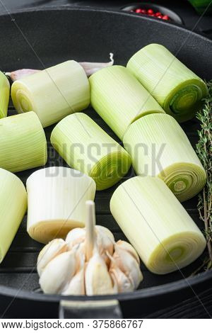 Raw Braised Leek Sultan On Grill Pan Uncooked With Herbs Ingredients  , On  Black Wooden Table Side