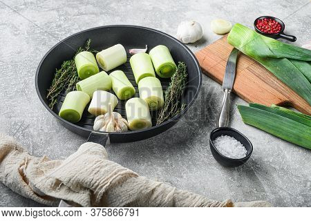 Raw Braised Leek Sultan On Grill Pan Uncooked With Herbs Ingredients  , On  Grey Textured Background