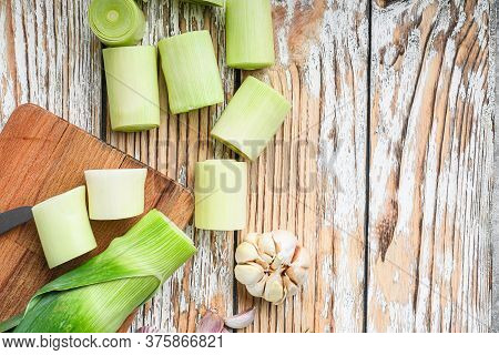Green Chopped Leek Sultan On Choppong Board Over White Wood Table Top View With Space For Text.