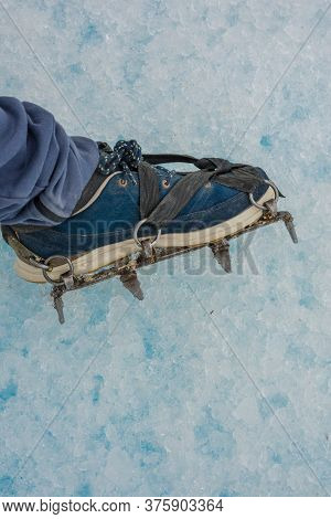 Foot With Crampons Ready To Walk On Snow