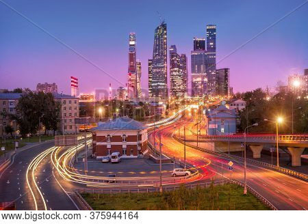 View Of The Moscow City Skyscrapers And Highways With Tracers Under Evening Pink Sky
