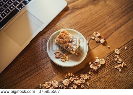 Homemade Sweets On A Light Table Background With Cereals, Purple Flowers And Notebook