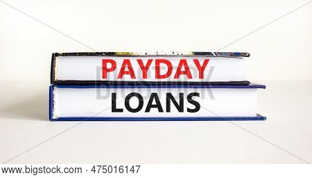 Payday Loans Symbol. Concept Words Payday Loans On Beautiful Books. Beautiful White Table White Back
