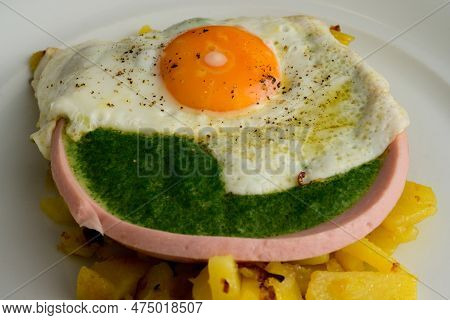 Fried Egg On Spinach In A Sausage Bowl And Roasted Potatoes Austrian Style