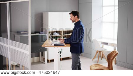Adjustable Height Desk Stand In Office Using Computer