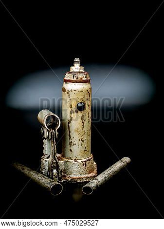 Old Manual Hydraulic Car Jack On A Black Background. Automotive Hydraulic Jack. Hand Tool. Tire Serv