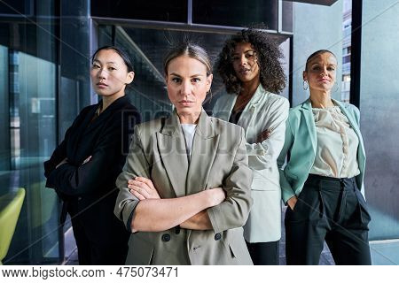 Four Multiracial Empowered Women Looking At Camera Confident And Serious At The Office.