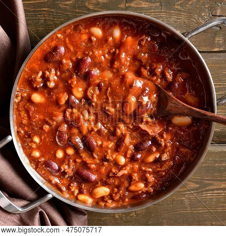 Stewed Beans With Ground Beef, Jalapeno Pepper And Bacon In Cooking Pan Over Wooden Background. Top 