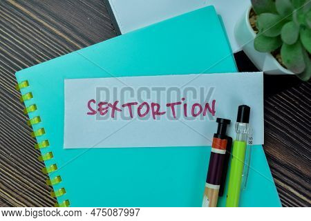 Concept Of Sextortion Write On Sticky Notes Isolated On Wooden Table.