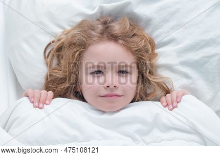 Kid Under Covers, Face Cover With Blanket. Child Wakes Up From Sleep In Bed. Kid Wakes Up In The Mor