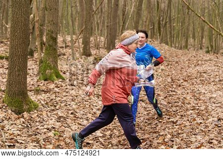 Cute Elderly Caucasian Women Wearing Sportswear Running Through A Forest