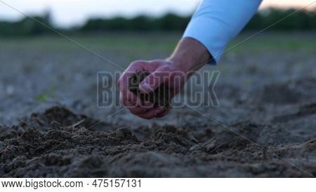 Close Up Of Man Farmer Hand Taking Ground In The Farm. Male Hands Checking Land Quality In Field Out