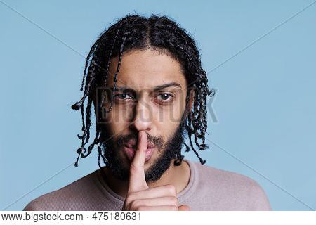 Arab Man Making Silent Gesture With Serious Facial Expression And Looking At Camera. Young Person Wi