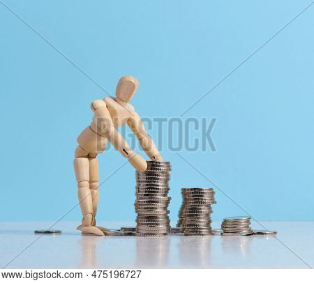 Wooden Dummy And Stacks Of White Coins, The Concept Of Accumulation Of Cash, Donation, Subsidy