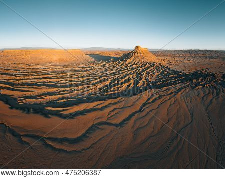 Factory Butte In The Caineville Badlands Of Utah. Aerial Drone Panorama During Sunrise.