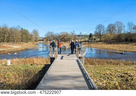 Tourists Admiring The Confluence Of The Rivers Brigach And Breg, Which Forms The Beginning And Origi