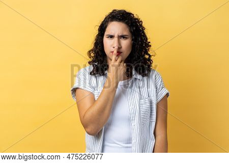Portrait Of Woman With Dark Wavy Hair Looking With Incredulous Gaze And Touching Nose, Gesturing You