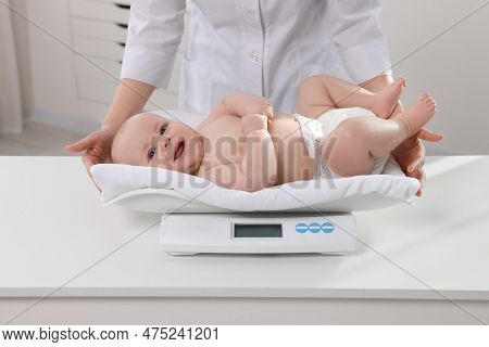Pediatrician Weighting Cute Little Baby In Clinic, Closeup