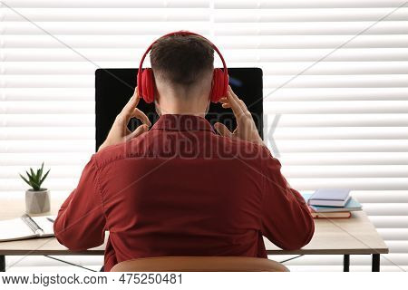 Man In Headphones Studying On Computer Indoors, Back View. Online Translation Course