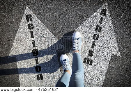 Philosophical Or Religious Position. Woman Standing On Road Marking Arrow With Word Atheism, Closeup