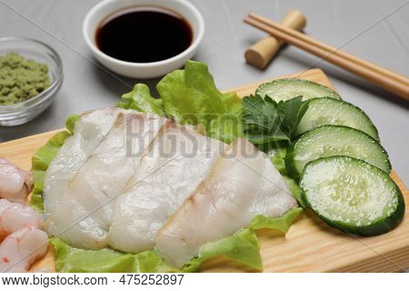Sashimi Set Served With Cucumber, Lettuce, Soy Sauce And Vasabi On Light Grey Table, Closeup