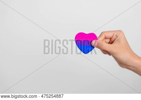 Bisexuality Celebrate Day And Lgbt Pride Month,  Lgbtq+ Or Lgbtqia+ Concept. Hand Holding Purple, Pi
