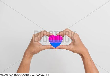 Bisexuality Celebrate Day And Lgbt Pride Month,  Lgbtq+ Or Lgbtqia+ Concept. Hand Holding Purple, Pi