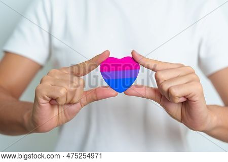 Bisexuality Celebrate Day And Lgbt Pride Month,  Lgbtq+ Or Lgbtqia+ Concept. Hand Holding Purple, Pi