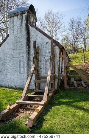 A Crack In The Corner Of A Historic Colonial Pennsylvania  White Stone Cottage Is Braced By Large Wo