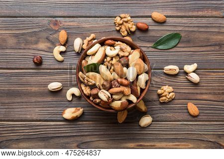 Mixed Nuts In Bowl. Mix Of Various Nuts On Colored Background. Pistachios, Cashews, Walnuts, Hazelnu
