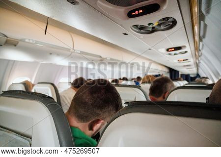 A Group Of People Enjoying A Journey In The Spacious Interior Of An Air Vehicle, Complete With Comfo