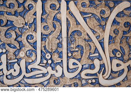 Details Of Stucco Decoration With An Arabic Writings Painted In Blue On The Palaces Walls In Alhambr