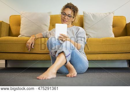 Easy Relaxed Lady At Home Reading And Using Tablet Ereader Ebook Device Alone Witting On The Ground 