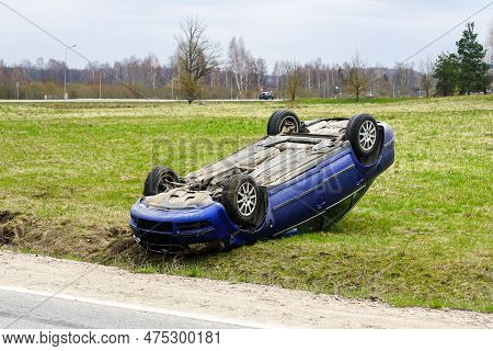 Car Accident Scene, A Passenger Car Left The Road And Overturned With Its Wheels Up, Overturned Car