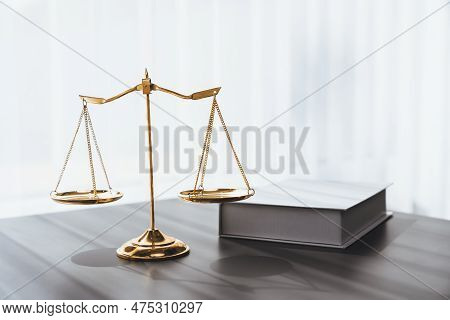 Shiny Golden Balanced Scale And Law Book On Desk In Law School As Concept Justice And Legal Symbol. 
