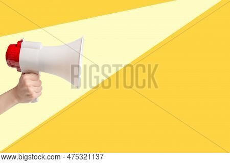 Megaphone In Woman Hands On A Yellolw Background.  Copy Space.