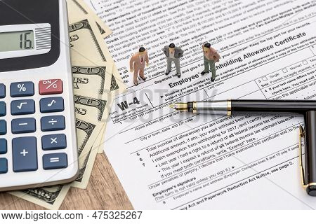 Tax Form W-4 With Mini Figures, Dollars And Calculator