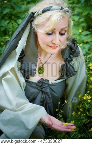 Adult Mature Woman 40-60 In A Green Long Fairy Dress In Forest. Photo Shoot In Style Of Dryad And Qu