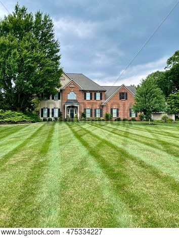 Lancaster, Pennsylvania - July 6, 2022: A Nicely Striped Mown Green Lawn With A House In The Backgro