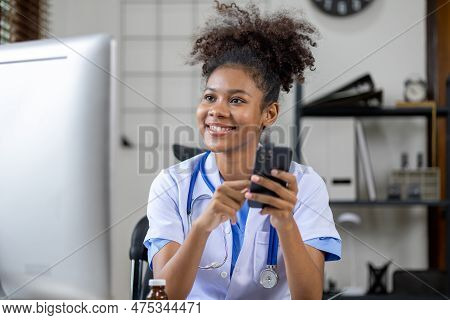 An American Female Doctor Is Using A Mobile Phone, She Is A General Practitioner And Internal Medici