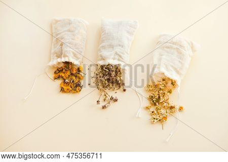 Dried Herbs At Cotton White Bags From Above. Sachets Filled With Medicinal Camomilla And Bunches Of 