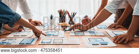 Panorama Shot Of Front-end Developer Team Brainstorming Ui And Ux Designs For Mobile App On Paper Wi