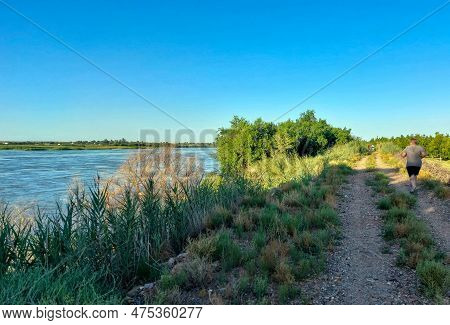 Upington, South Africa - Feb 24, 2023: Runners Doing A Parkrun On The Banks Of A Flooded Orange Rive