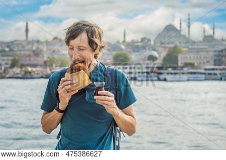 Man In Istanbul Having Breakfast With Simit And A Glass Of Turkish Tea. Glass Of Turkish Tea And Bag