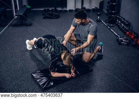 Ems Training Studio. Shot From Above Of A Female Athlete Wearing An Ems Suit And A Male Trainer In G