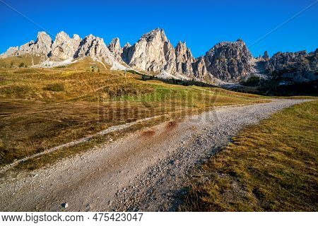 Dirt Road And Hiking Trail Track In Dolomites Mountain, Italy, In Front Of Pizes De Cir Ridge Mounta