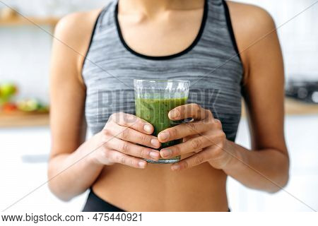 Close-up Photo Of A Green Fresh Smoothie In A Glass Cup In Female Hands. Sporty Woman Prepared Herse