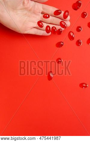 Krill Oil Capsules .omega Fatty Acids.flying Gelatin Red Krill Oil Capsules In A Hand On A Red Backg