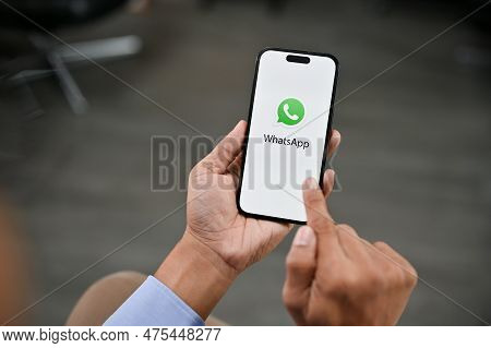 A Man Using Whatsapp On His Iphone. Whatsapp Logo On Iphone Screen Mockup